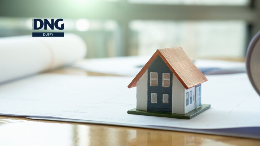 small model house on a desk symbolising real estate