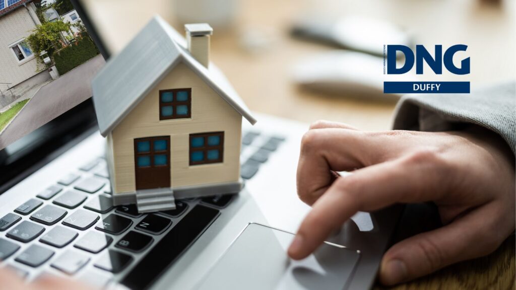 laptop with a model house on top of keyboard